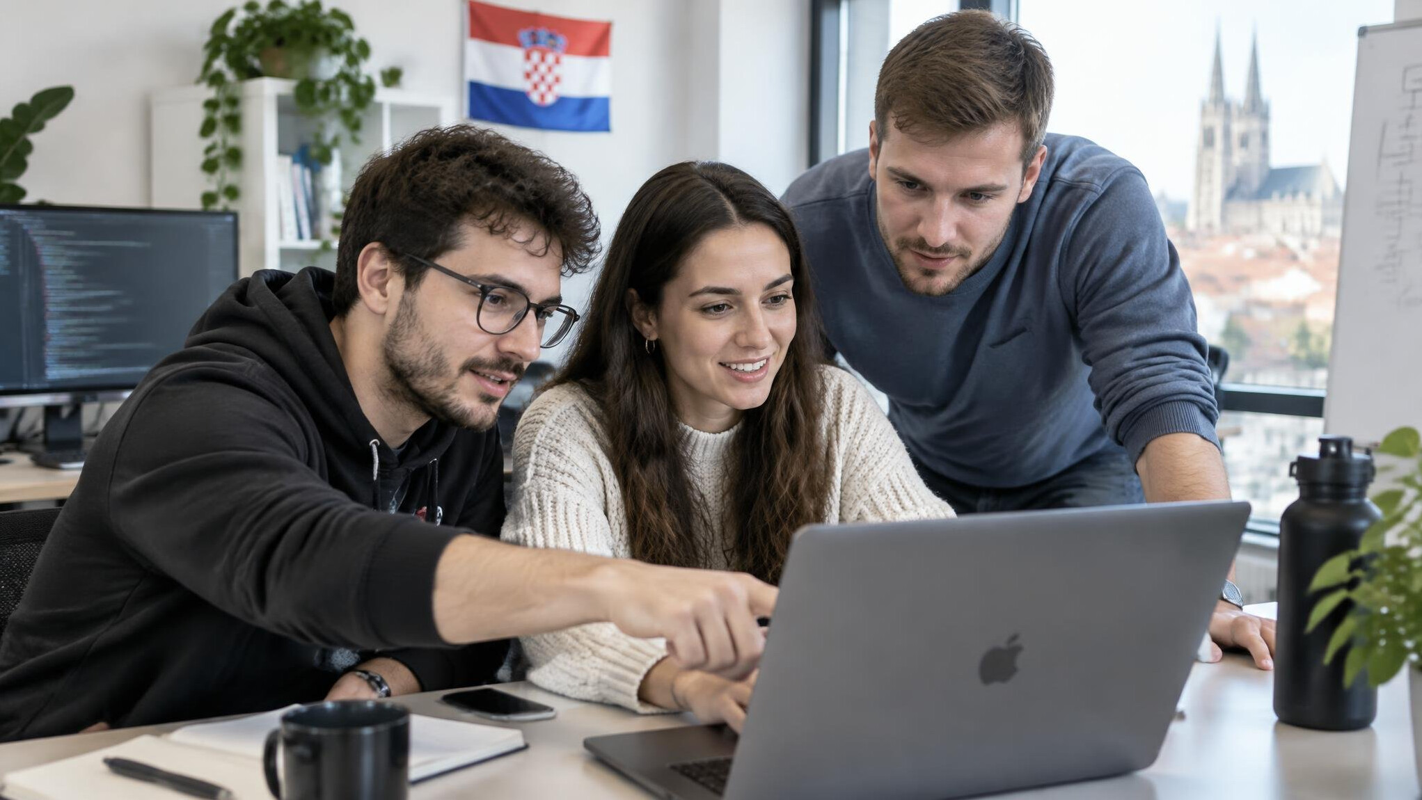 Small team of developers collaborating around a laptop